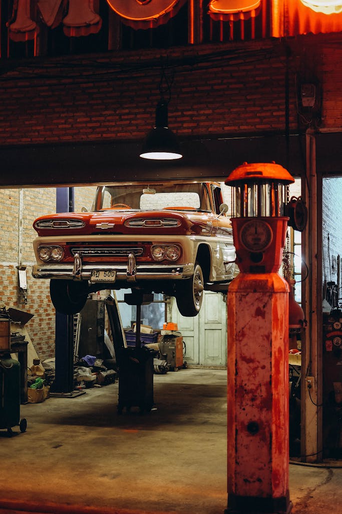 Classic car elevated in a Bangkok garage with retro elements highlighting vintage automotive culture.